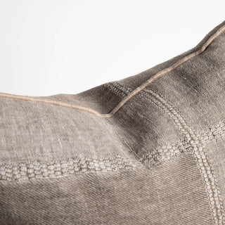 Close-up of a textured fabric pillow with a subtle pattern on a light background