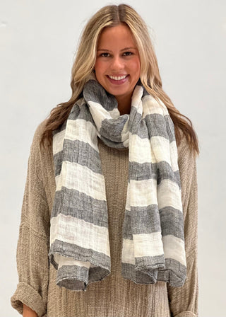 Woman wearing a striped scarf on a plain background