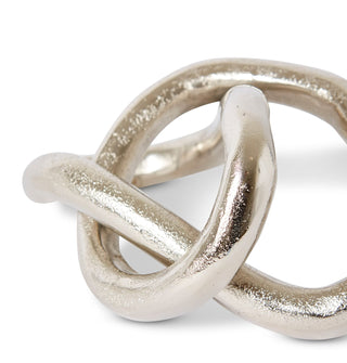 Silver knot-shaped decorative item on a white background