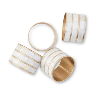 Set of four gold and white striped napkin rings on a white background