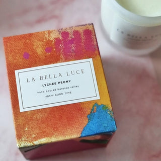 La Bella Luce lychee peony candle box on a pink surface