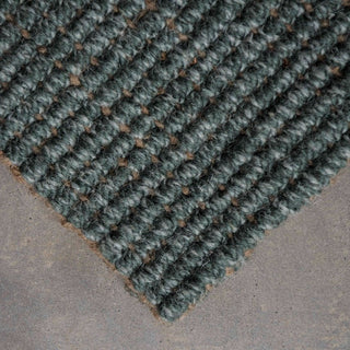 Textured green rug on a gray surface