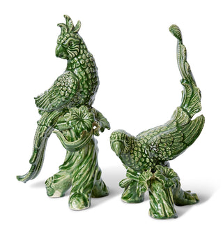 Two green ceramic parrot statues on a white background