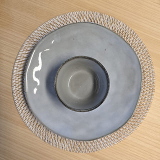 Gray ceramic dish with textured rim on a wooden surface