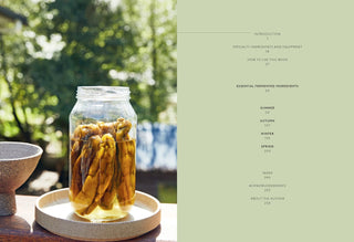 Book with a jar of pickled vegetables on a table outdoors