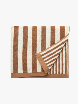 Striped towel with brown and white stripes on a white background