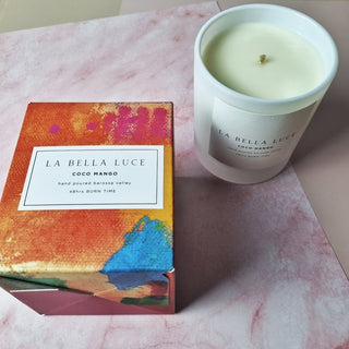 La Bella Luce candle and packaging on a pink surface