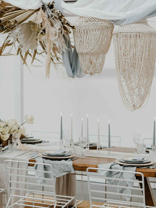 Elegant dining table setting with decorative elements and white chairs.