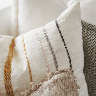 Close-up of textured pillows with striped patterns on a neutral background