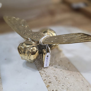 Gold eagle head sculpture on a textured surface with a blurred background