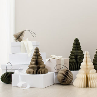 Decorative paper trees and gift boxes on a light surface with a neutral background