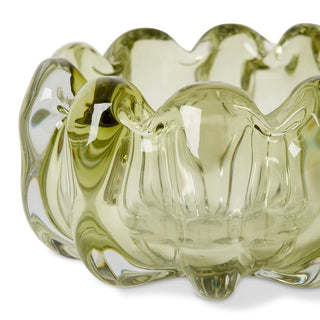Green glass bowl with wavy design on a white background