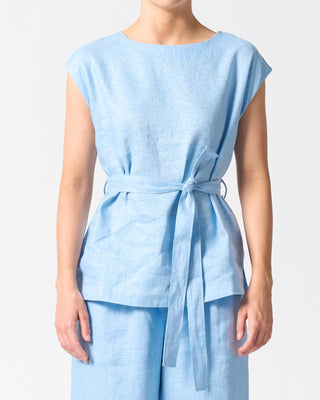 Light blue sleeveless top with a belt and matching light blue pants on a plain background