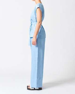 Person wearing a light blue outfit on a white background