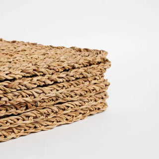 Stack of woven placemats on a white background