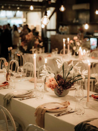 Decorated table setting with candles and floral arrangements in a restaurant.