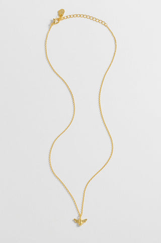 Gold necklace with a small pendant on a light gray background