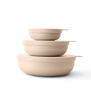 Set of three beige ceramic bowls stacked on a white background