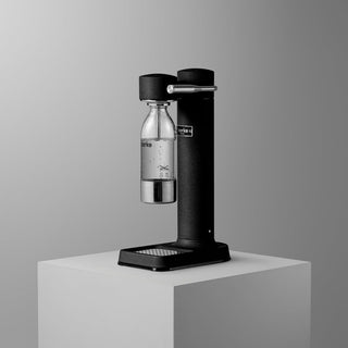 Black soda maker with a bottle on a gray background