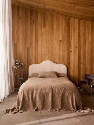 Bedroom with wooden wall and beige bedspread