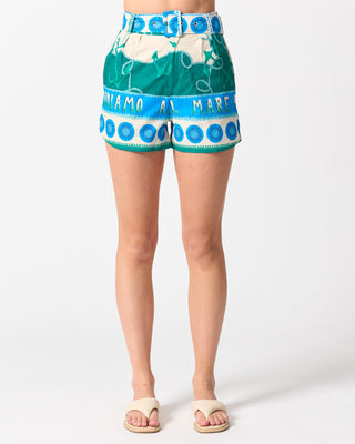 Green shorts with blue and white pattern worn by a person on a white background