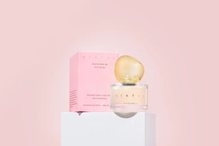 Perfume bottle and packaging on a pink background
