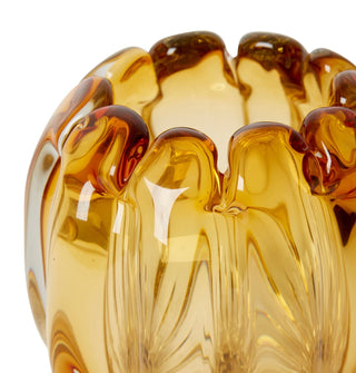 Close-up of a amber-colored glass bowl with a textured surface on a white background