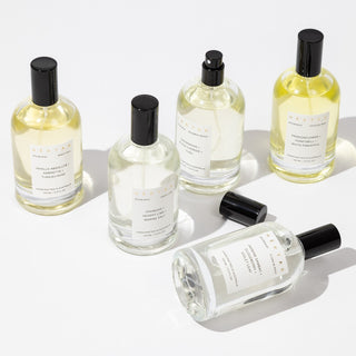 Set of six perfume bottles with black caps on a white background