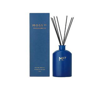 Blue diffuser bottle with black sticks and packaging labeled 'Moss St. Fragrances' on a white background