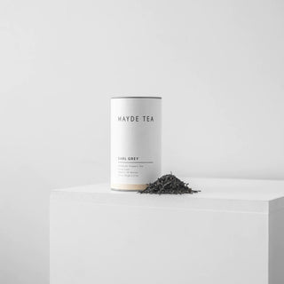 Mayde Tea Earl Grey canister with loose tea on a white surface