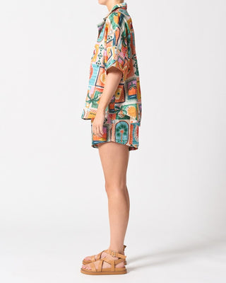 Person wearing a colorful patterned shirt and shorts on a white background