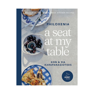 Book cover of 'A Seat at My Table' by Philoxenia featuring Greek cuisine.