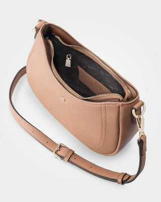 Tan leather handbag with a shoulder strap on a light gray background