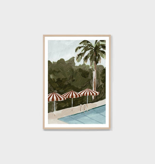 Framed artwork of a pool scene with striped umbrellas and a palm tree.