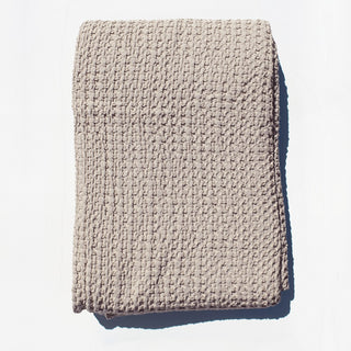 Textured beige blanket on a light white background