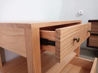 Wooden drawer unit with a drawer open on a light-colored floor.