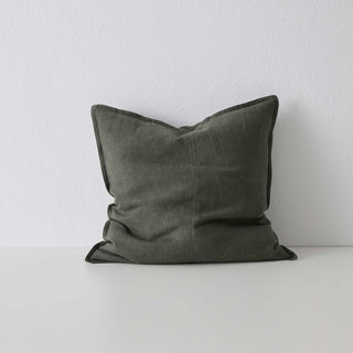 Dark gray pillow on a white surface with a light gray background