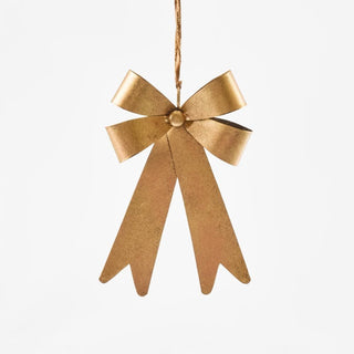 Gold bow-shaped ornament hanging on a white background