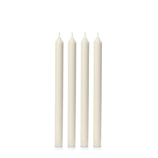 Four white candles of varying heights on a white background
