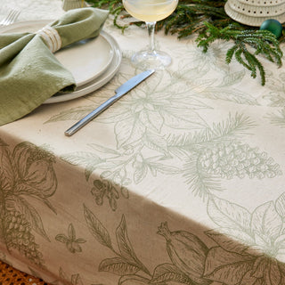 Table setting with a decorative tablecloth featuring nature-themed patterns.