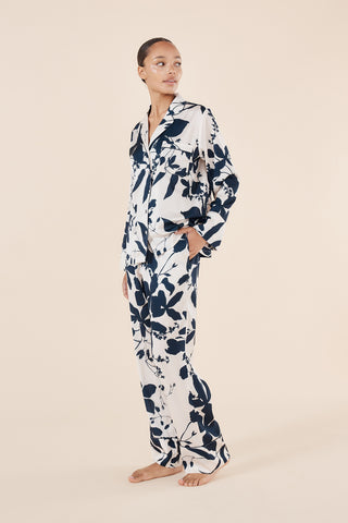 Woman wearing a floral pajama set on a beige background