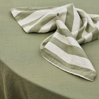 Green and white striped napkin on a green surface