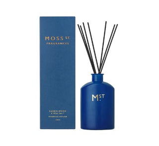 Blue fragrance diffuser with black sticks and matching box labeled 'Moss St. Fragrances' on a white background.
