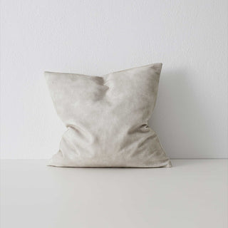 Beige pillow on a white surface with a light gray background