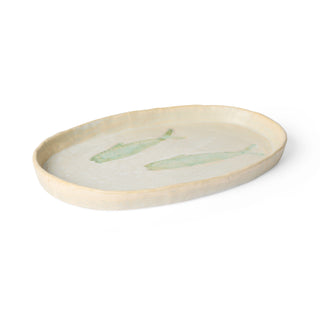 Oval ceramic tray with green leaf design on a white background