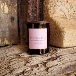 Candle with a pink label on a rustic wooden surface