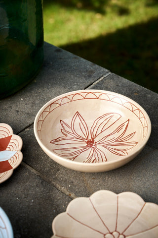 Ceramic dish with floral design on a stone surface