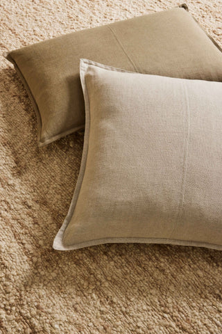 Two beige pillows on a textured surface