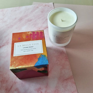 La Bella Luce candle and packaging on a pink marble surface