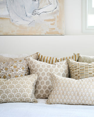 Patterned pillows on a sofa with abstract art in the background